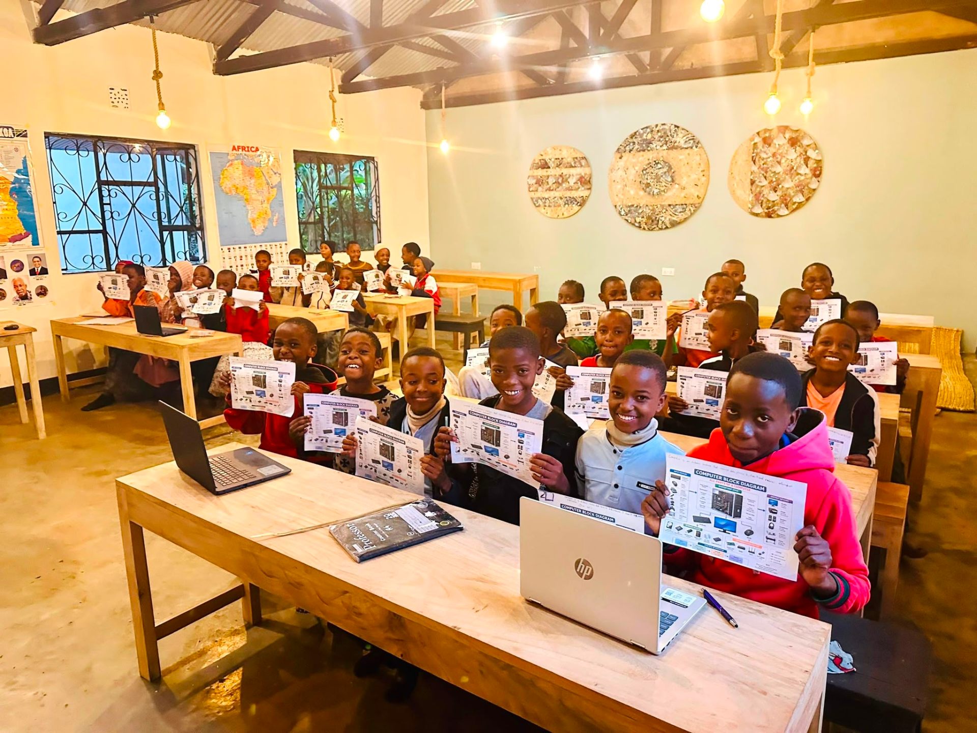 Children in computer class holding learning diagrams