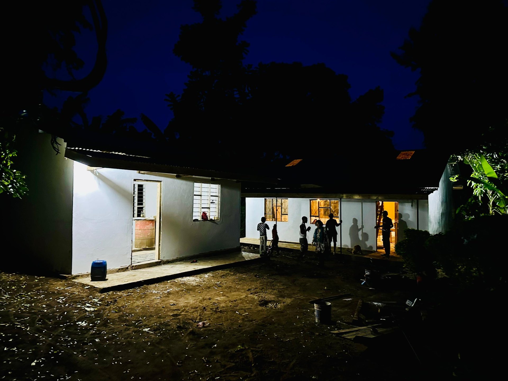 School building at night with community gathering